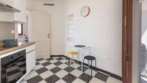 Una cocina con piso a cuadros, un reloj y una pared con texto motivacional.