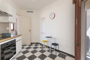 A kitchen with a checkered floor, a clock, and a wall with motivational text. - Casa Tramonti - Trilo Comfort by BarbarHouse (Santa Maria di Leuca)