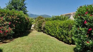 Un chemin menant à un bâtiment, avec un ciel dégagé et des montagnes lointaines en arrière-plan.
