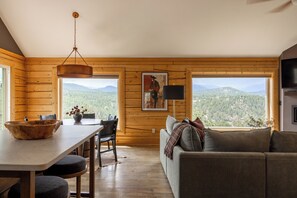 Ein Interieur einer Holzhütte mit Essbereich, einer Couch und einem Bild an der Wand.