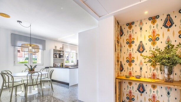 Eine moderne Küche mit weißen Schränken, einem eingebauten Backofen und einem Fenster.