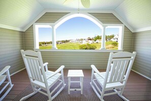 A covered porch with two white Adirondack chairs and a small table, overlooking a residential area. - Better Together Large home in Portsmouth (Portsmouth)