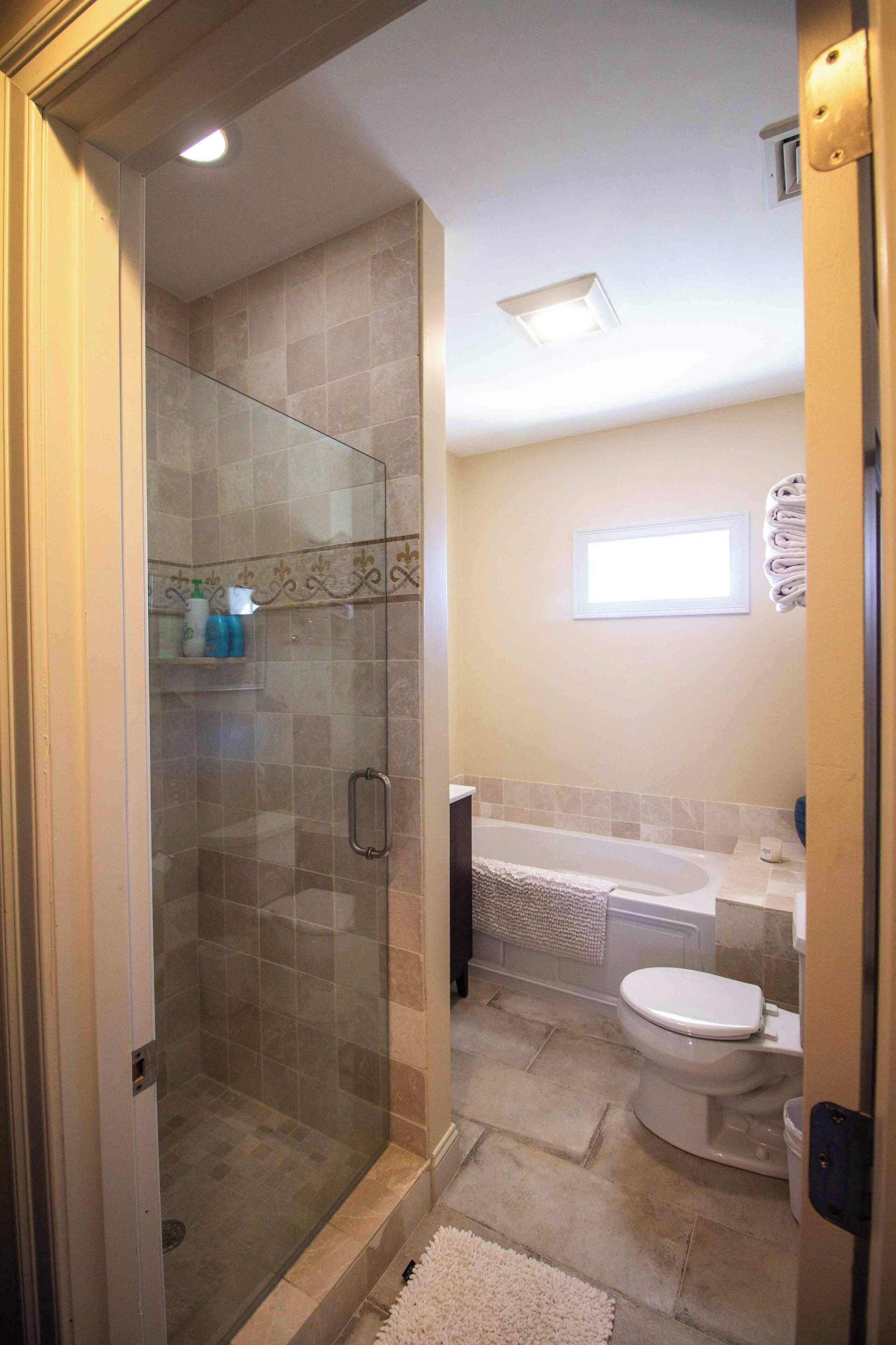 A bathroom with a glass-enclosed shower, a toilet, and a bathtub.