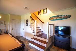 A home interior with a pool table, a staircase, a television, and a sign that reads 'BETTER TOGETHER JACK JOHNSON'. - Better Together Large home in Portsmouth (Portsmouth)