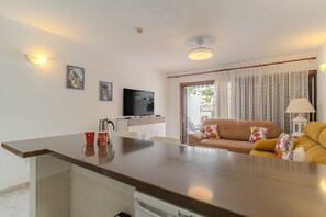 A modern living area with a sofa, a television, and a dining table. - Vacation Apartment 'Victoria Court 2 51' with Shared Pool, Private Terrace and Wi-Fi (Arona)