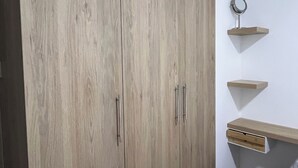 A bedroom with a wardrobe, a bedside table, and a small shelf unit. - Rincón del Atardecer Boutique Apartment (Arequipa)