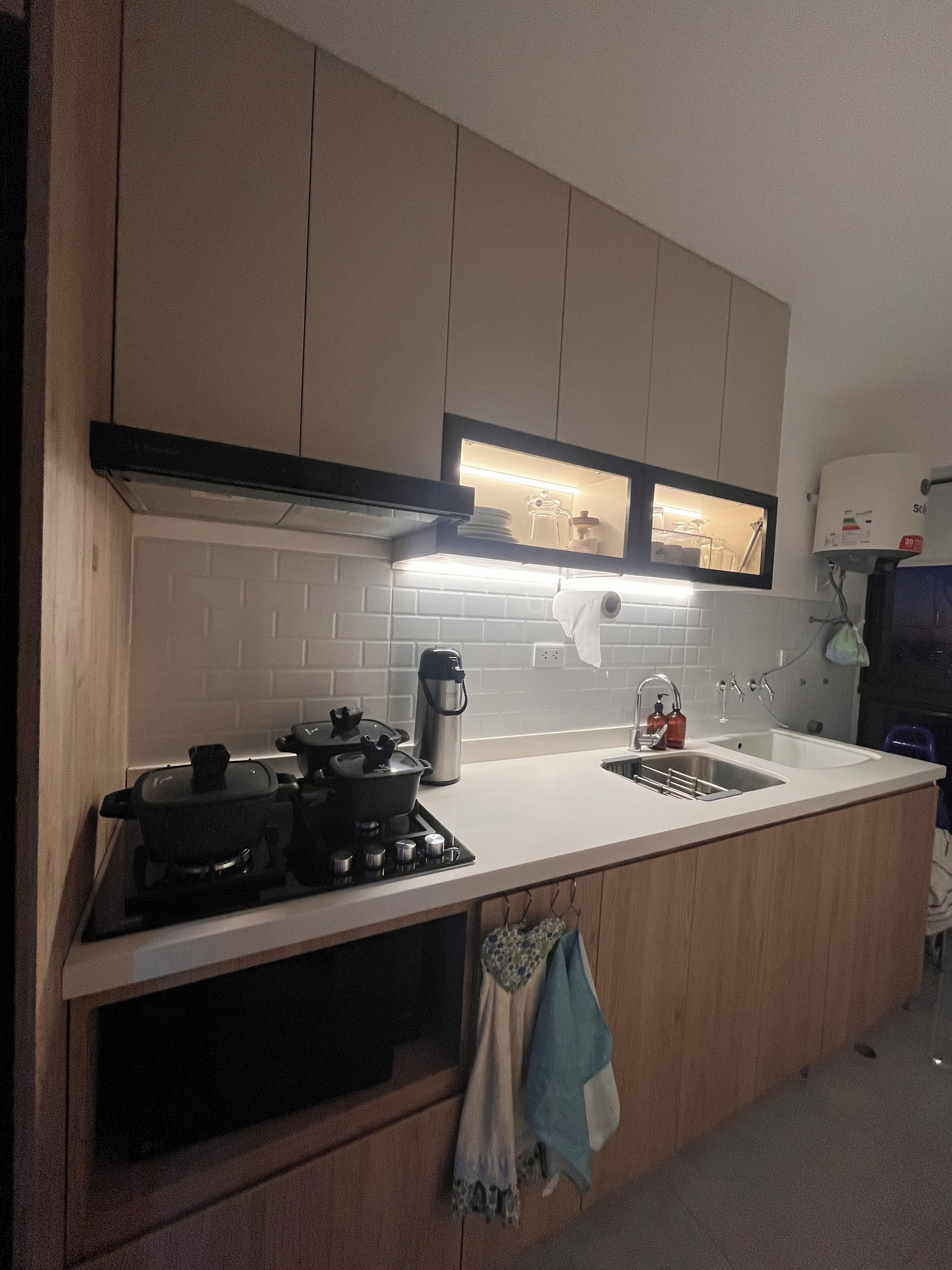 Una cocina con estufa, pileta y alacenas.