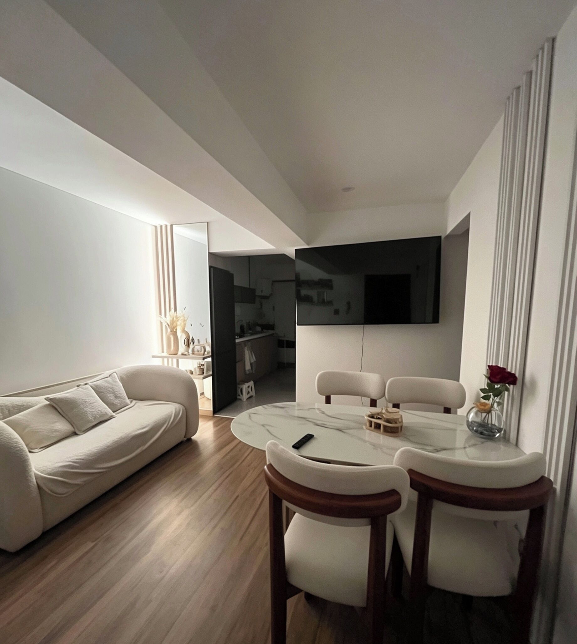 A modern living room with a sofa, a dining table with chairs, and a kitchen in the background.