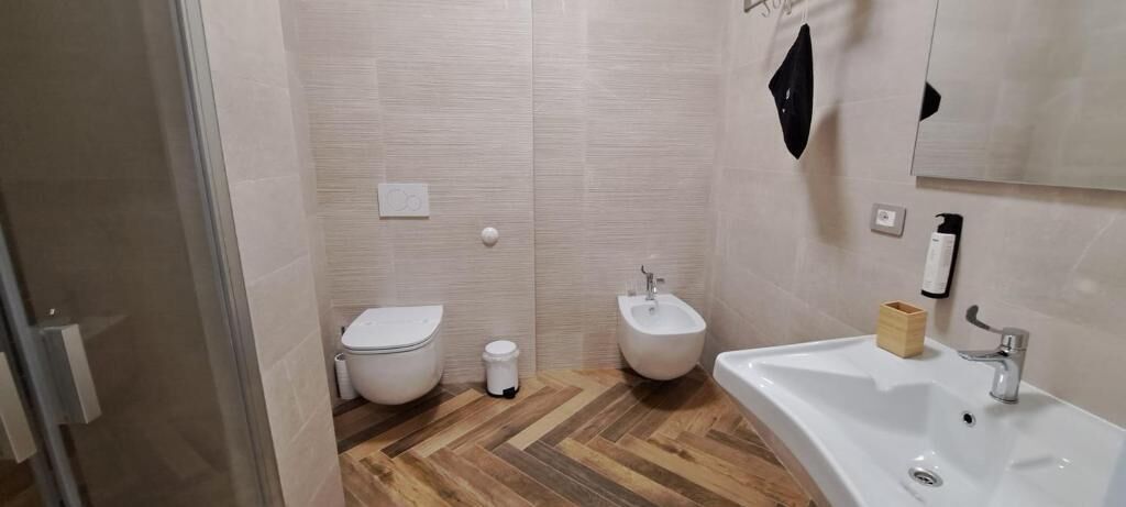Une salle de bain équipée de toilettes, d’un bidet et d’un lavabo.