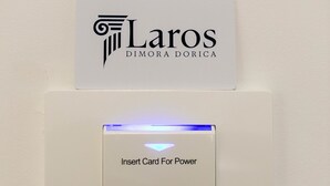 Un dispositivo montado en la pared con una ranura para tarjeta y un botón que dice 'Insertar Tarjeta Para Energía'.