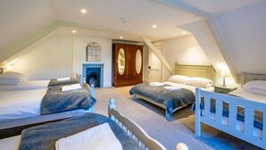 Une chambre avec deux lits, une cheminée et une armoire.