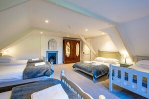 A bedroom with two beds, a fireplace, and a wardrobe.