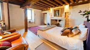 A room with a bed, a fireplace, a wooden ceiling, and a window. - Mounicat - Four Bedroom Villa, Sleeps 10 (Baleyssagues)