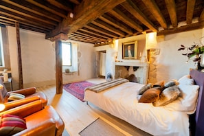 A room with a bed, a fireplace, a wooden ceiling, and a window. - Mounicat - Four Bedroom Villa, Sleeps 10 (Baleyssagues)
