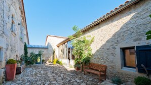 A narrow stone-paved alley with a bench, potted plants, and traditional stone buildings. - Mounicat - Four Bedroom Villa, Sleeps 10 (Baleyssagues)