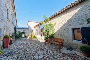 A narrow stone-paved alley with a bench, potted plants, and traditional stone buildings. - Mounicat - Four Bedroom Villa, Sleeps 10 (Baleyssagues)
