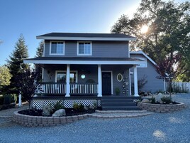 A two-story house with a front porch, a garage, and a well-maintained garden.