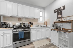 A modern kitchen with white cabinetry, stainless steel appliances, and a coffee station. - Two Bedrooms • Coffee Station • Family Friendly (Jersey City)