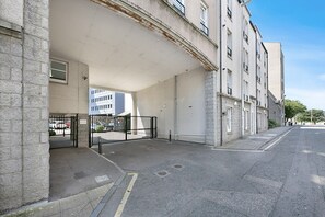 A building with a covered entrance, a gated parking area, and a clear sky. - Chapel Street Suite - Grampian Lettings (Aberdeen)