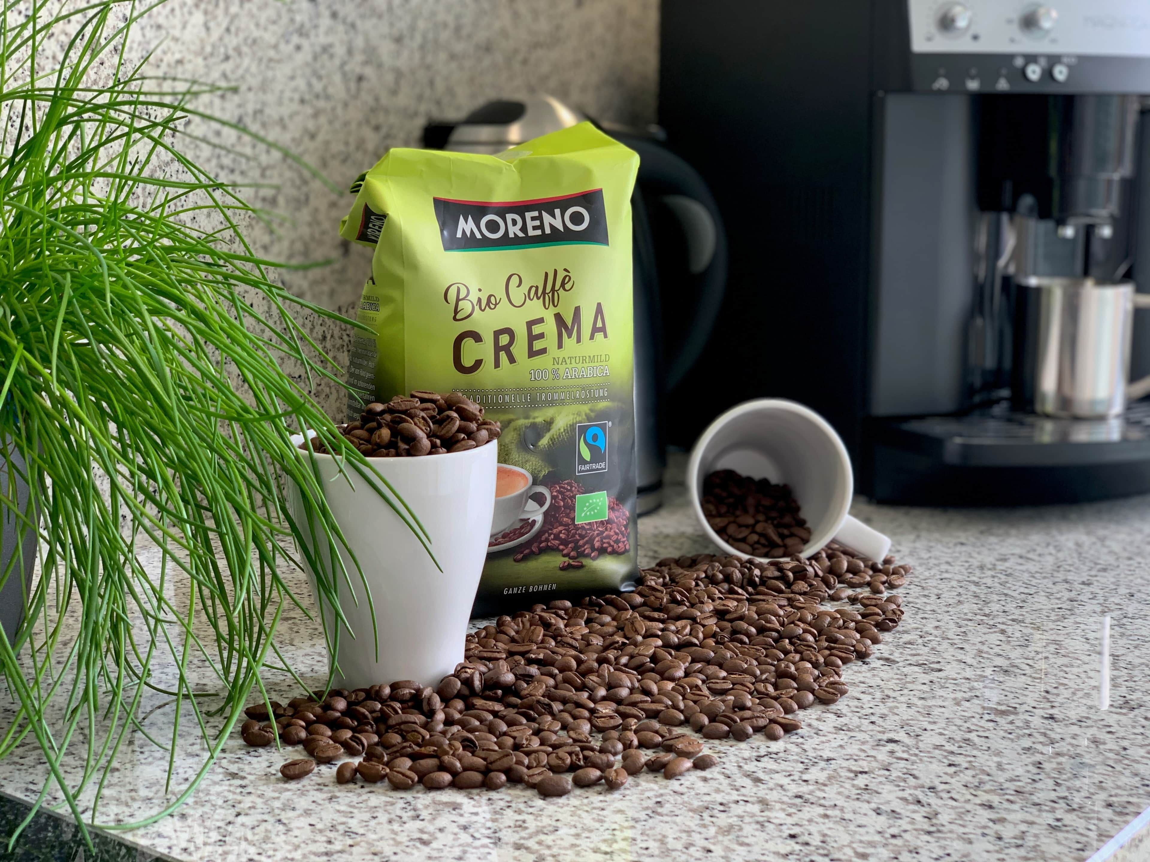 A coffee bag, a cup, and coffee beans on a countertop.