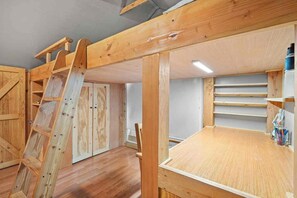 A room with a loft bed, wooden ladder, and built-in shelving. - Historic Old Town Attic Loft—Steps from Albuquerque’s Best Sights (Albuquerque)