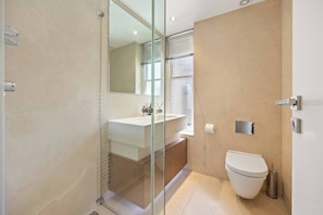 A modern bathroom with a glass shower enclosure, a sink, and a toilet. - The Duke Residence / 3Bed 2.5Bath in Mayfair (Greater London)