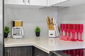 A kitchen counter with a coffee maker, a knife block, and a row of red wine glasses. - Vibrant Nashville Retreat, Pool and Glam Room (Nashville)