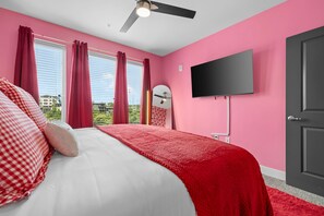 Een slaapkamer met een bed, een televisie en een deur.