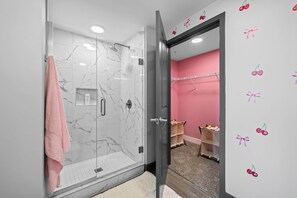 A bathroom with a glass shower enclosure, a pink towel, and a vanity with a mirror. - Vibrant Nashville Retreat, Pool and Glam Room (Nashville)