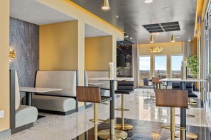 A modern restaurant with high ceilings, contemporary furniture, and large windows offering a view. - Vibrant Nashville Retreat, Pool and Glam Room (Nashville)