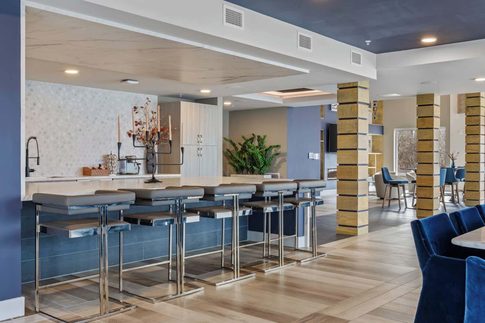 Una cocina moderna con barra, que incluye electrodomésticos de acero inoxidable, un salpicadero decorativo y una isla central.