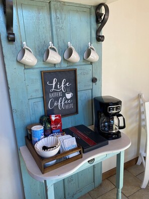 Un comptoir de cuisine avec une machine à café, un cadre décoratif et un plateau contenant des aliments pour le petit-déjeuner.