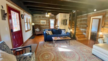 Un salon chaleureux avec un canapé bleu, une table basse en bois et un tapis à motifs.
