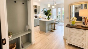 A modern kitchen with a central island, pendant lighting, and a view to the dining area. - The Jardin Violet Suite Near Downtown (Savannah)