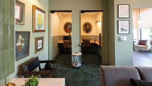 En hotelllobby med inramade konstverk, en receptionsdisk och en sittgrupp.