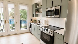 Una cocina moderna con horno empotrado, microondas y refrigerador de acero inoxidable.