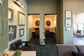 A hotel lobby with framed artwork, a reception desk, and a seating area. - The Jardin Briar Suite | Near Downtown (Savannah)