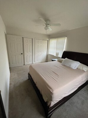 A bedroom with a bed, a ceiling fan, and a window with blinds. - Charming 3-bedroom house (Euless)