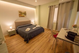 Una camera d'albergo con un letto, comodini, una scrivania e una sedia.