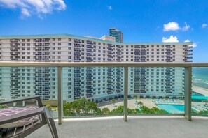 A high-rise hotel with multiple balconies, a pool area, and a view of the ocean. - Vive la experciencia frente al mar (Hollywood)
