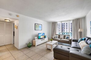 A modern living room with a television, sofa, and coffee table. - Vive la experciencia frente al mar (Hollywood)