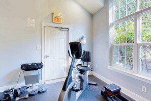 A home gym with exercise equipment, a door, and a window with a view of greenery. - Rehoboth Crossing - 37063 Turnstone Cir (Rehoboth Beach)