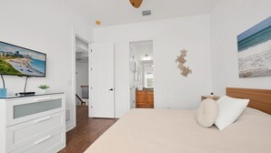 A bedroom with a bed, a dresser, a television, and a painting on the wall. - Game Room Arcade Games Private Pool Guest House-7521 (Kissimmee)