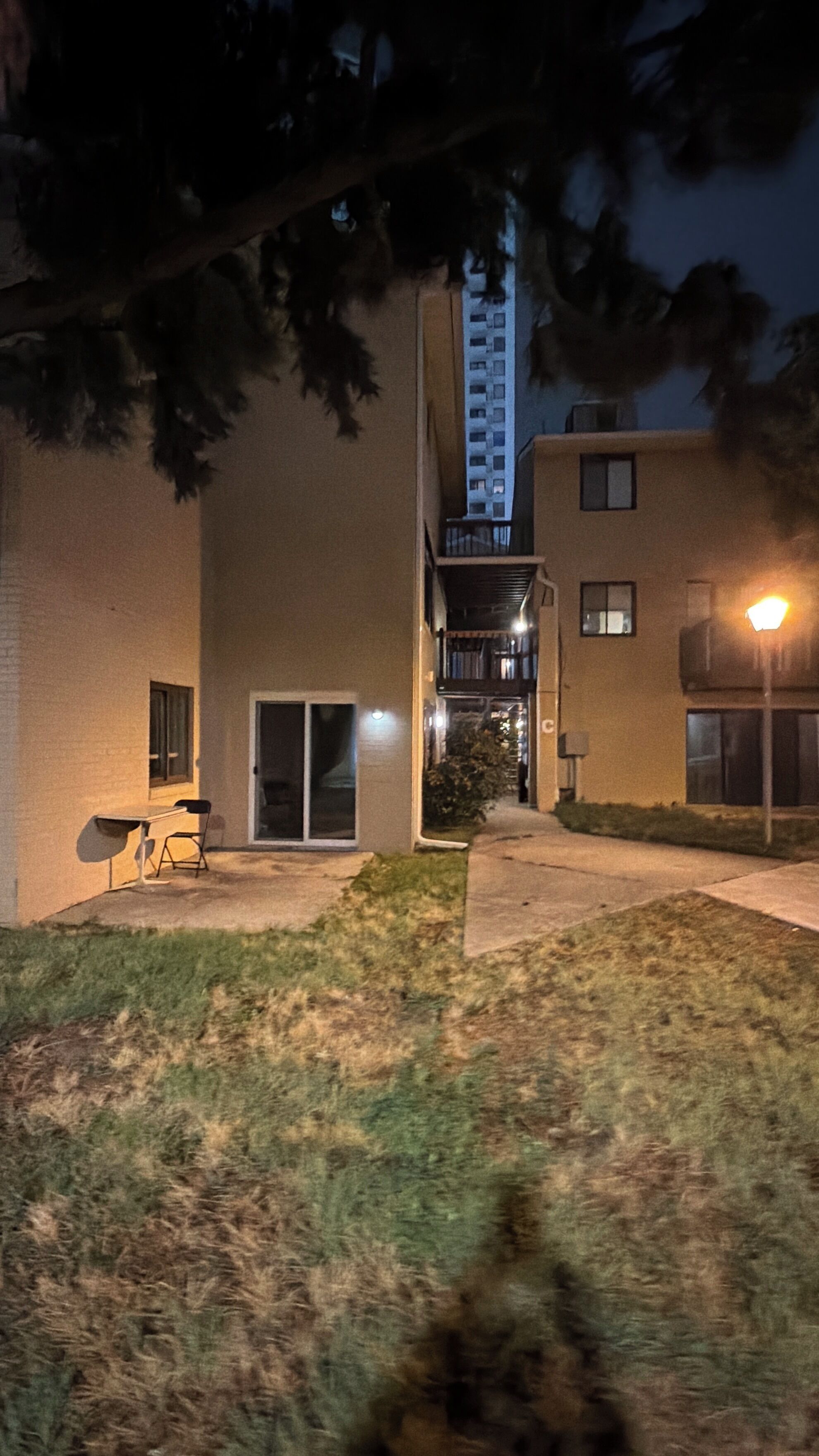 Ein Gebäude mit einer flachen Fassade, einem gut sichtbaren Eingang und einer kleinen Außen-Sitzgelegenheit.