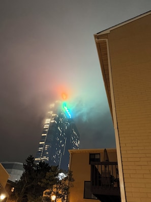 A high-rise building with illuminated windows and a neon sign at the top.
