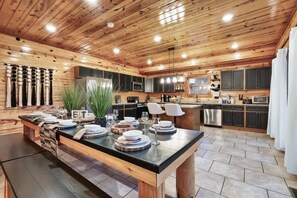 A spacious kitchen with wooden ceiling and cabinetry, a central island with seating, and modern appliances. - Brand New Design! Huge Pool Cabin@ Blackhawk Lodge (Sevierville)