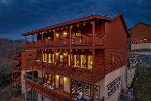 A multi-story wooden building with balconies and outdoor seating areas. - Brand New Design! Huge Pool Cabin@ Blackhawk Lodge (Sevierville)