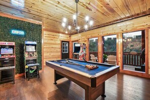 A pool table in a room with wooden walls and a green wall decoration. - Brand New Design! Huge Pool Cabin@ Blackhawk Lodge (Sevierville)