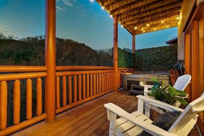 A wooden deck with a barbecue area, outdoor seating, and a view of the surrounding landscape. - Brand New Design! Huge Pool Cabin@ Blackhawk Lodge (Sevierville)