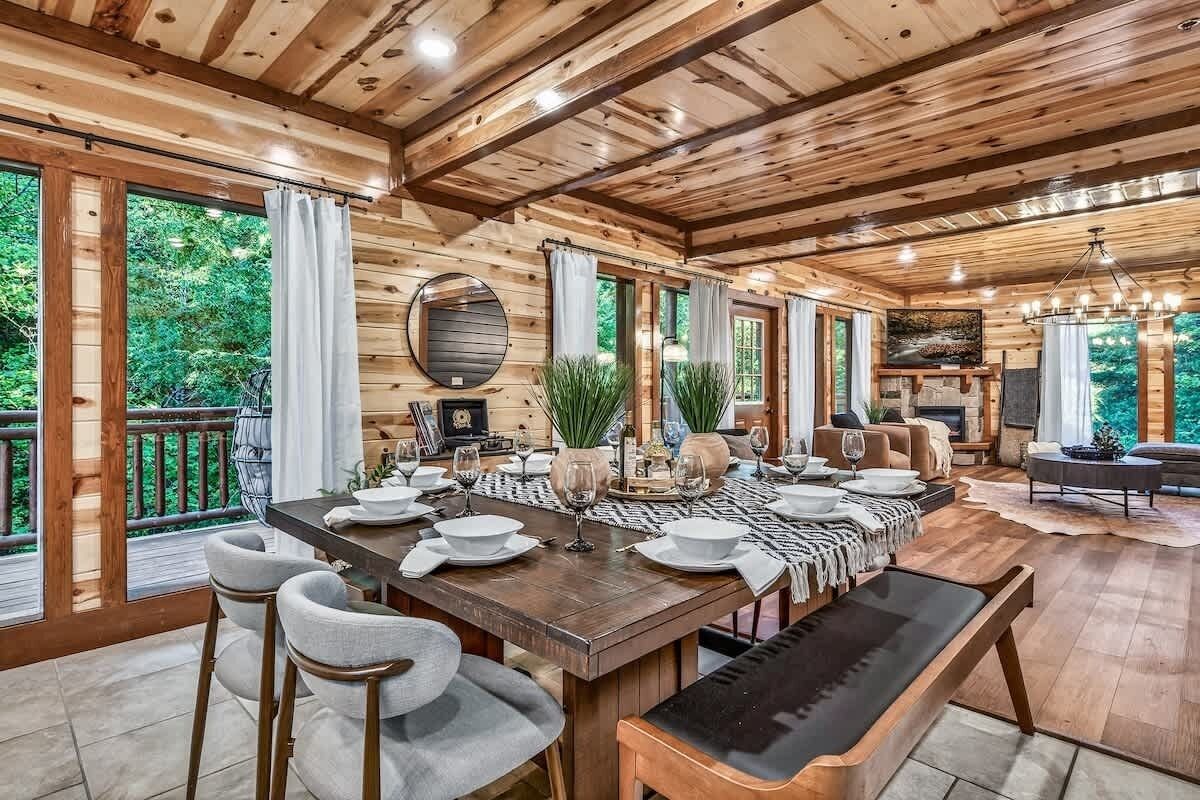 A wooden interior with a dining table set for six, surrounded by chairs.